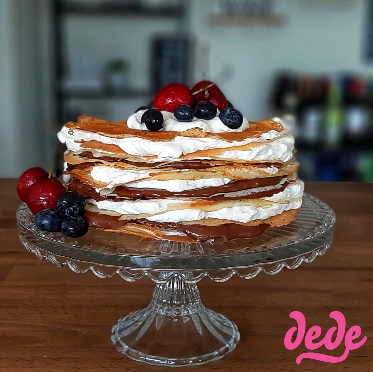 Autor: Chef Haydée Salcedo Objio (Dedé Bakery)
Ingredientes
Para los CREPES
•	4 huevos
•	2 taza leche entera 
•	2 taza harina
•	2 cucharadas azúcar
•	1 pizca de sal
Para la CREMA DE QUESO
•	½ Libra queso crema 
•	½  Taza azúcar glass
•	½  Barra mantequilla Lurpak
•	½  Taza crema de leche para montar 
•	1 cucharadita vainilla
Para MONTAR EL CREPE CAKE
•	14 Crepes fríos
•	Receta de crema de queso
•	1 Nutella pequeña
•	Frutas 

PREPARACIÓN
Preparación de los Crepes
1.	Mezclar todos los ingredientes. Batir hasta eliminar totalmente los grumos.
Llevar la mezcla a la nevera unos 20 minutos.
2.	En un sartén (use uno de 18 pulgadas), agregar varias gotas de aceite y a medida que se caliente, con ayuda de una brocha o papel cubrir toda la superficie (sin dejar nada de excesos).
3.	Cuando esté caliente, agregar una cucharada sopera en el centro y dar vueltas al sarten para que la mezcla se esparza (Recuerde que los crepes deben quedar finitos). Pasado como un minuto, cuando se empiecen a despegar de los bordes, dar vueltas.
4.	Repetir hasta que se termine la mezcla. Dejar que todos se enfríen. (Para el montaje de la imagen se usaron un total de 14 crepes).
Preparación de los Crepes
1.	Cremar queso, mantequilla, azúcar y vainilla
2.	Agregar la crema de leche para montar y batir hasta que casi doble su tamaño.
Preparación de los Crepes
1.	Colocar un crepe y un poco de crema de queso casi hasta el borde y repetir hasta terminar. Cada 2 crepes agregar nutella.
2.	Decorar arriba con más crema y fruta de tu preferencia.  
