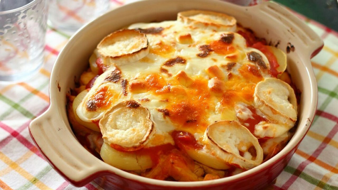 Ingredientes:
Berenjena, 1 grande o 2 pequeñas
Salsa de tomate, 250 g
Pollo asado o cocido, 300 g
Patatas cocidas, 2
Quesos variados, 100 g (Cheddar, Gouda y rulo de cabra)
Salsa bechamel, 3 o 4 cucharadas
Sal
Aceite de oliva para engrasar el molde

Preparación: 10 min / Cocción: 20 min / Comensales: 2 ó 3

1. Cortamos las berenjenas en rodajas de 1 centímetro de grosor y las pasamos por la plancha un par de minutos por cada lado.
2. Engrasamos una fuente de horno, colocamos las rodajas de berenjena, cubrimos con la mitad de la salsa de tomate, repartimos el pollo por encima, colocamos las patatas cocidas en rodajas, luego el resto de la salsa de tomate, la bechamel y finalmente el queso, que puede ser rallado o en trozos.
3. Horneamos en horno precalentado a 200ºC durante 15 minutos y después gratinamos durante unos 5 – 7 minutos más a 250ºC hasta que el queso esté completamente fundido.
4. Servimos caliente.

Fuente: Elespanol.com