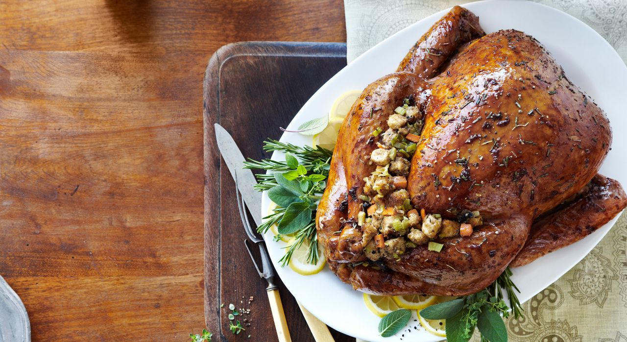 Ingredientes:
Para el adobo
200gr de mantequilla sin sal
3 cdas de sal
2cdas de salvia picada o cilantro
Echalote (Puede sustituirse por ajo)
1 cdta. De pimienta negra molida 

Para el pavo
1 Pavo
2 zanahorias cortadas en rodajas
3 varas de apio cortadas en medias lunas 
Meda cebolla fileteada
2 tazas de caldo de pollo
Hilo de cáñamo o fibra de hojas de plátano para amarrar
Para el relleno
Las menudencias del pavo (corazón, hígado, etc.)
½ kilo pan campesino cubos de 5cm de grosor 
3 manzanas peladas y picadas
2 tazas de castañas
2 tazas de caldo de pollo
Aceite de oliva
Media cebolla picada
Sal y pimienta al gusto
¼ de taza de perejil picado
2 cdas. de salvia picada 
2 cdas. de hojas de romero picada
1 cda. de tomillo picado 

Preparación
- Para preparar el aderezo que untaremos en el pavo, mezclamos en un tazón la  salvia y el echalote (o ajo) picado, la mantequilla a temperatura ambiente, la sal y la pimienta. Revolver bien con el tenedor hasta obtener una mezcla homogénea. Utilizar este adobo para untar al pavo por fuera y por dentro. 
- Colocar las zanahorias, el apio y la cebolla picada, el cuello y las patas del pavo sobre un molde donde irá el pavo al horno. Encima de la misma parrilla, colocar el pavo marinado y dejar reposar por una hora.
- Para preparar el relleno, hacemos un corte en forma de cruz en cada castaña, procurando romper la primera capa de cada una.  La echamos en agua hirviendo y la dejamos cocer por 15 minutos. Una vez transcurrido el tiempo, la escurrimos y removemos la cascara dura exterior y luego la interior. La picamos y la reservamos.
- En una cacerola calentamos el aceite de oliva, agregamos el apio y la cebolla picada. Dejamos cocer a fuego medio mientras vamos removiendo de vez en cuando durante 7 minutos. Añadimos las rebanadas de manzana pelada y las menudencias picadas. Sazonamos con sal y pimienta. Continuamos cociendo y moviendo ocasionalmente hasta que las manzanas estén tiernas y las menudencias cocidas. Esto es aproximadamente cinco minutos. Luego agregamos el perejil, la salvia fresca, el romero y el tomillo picado. Dejar cocer un minuto más.
- Agregar el sofrito anterior sobre el pan campesino que fue tostado previamente. Agregar también las castañas picadas y las dos tazas de caldo de pollo  caliente. Revolver bien y dejamos enfriar. (Este relleno se puede preparar una la noche previa y dejar refrigerado hasta el momento del uso).
- Para hornear el pavo, primero rellenamos la cavidad interior con la mezcla del relleno y amarramos bien las patas con un hilo de cáñamo. Calentamos el horno a 400°F/220°C y metemos el pavo al horno previamente calentado por 45 minutos. Retiramos el pavo del horno, agregamos las dos tazas de caldo de pollo encima, cubrimos perfectamente con papel aluminio y llevamos al horno por dos o dos horas y media más bañando con sus jugos de vez en cuando. Dejamos destapado para que se dore los últimos 30 minutos de cocción. El pavo estará listo cuando la pechuga interna del pago marque una temperatura de 170°F o 76°C.
- Para preparar la salsa, desmenuzamos la carne del pescuezo del pavo y la molemos en la licuadora con los jugos del pavo. 
- Para servir, dejamos enfriar el pavo 30 minutos antes de rebanarlo, removemos el relleno interno del pavo y lo ponemos en un tazón.  Servimos el pavo rebanado, acompañado con el relleno y bañado con los jugos. 

Recomendación: Adquirir un termómetro para carnes para insertarlo en el pavo y saber cuando esté listo.
