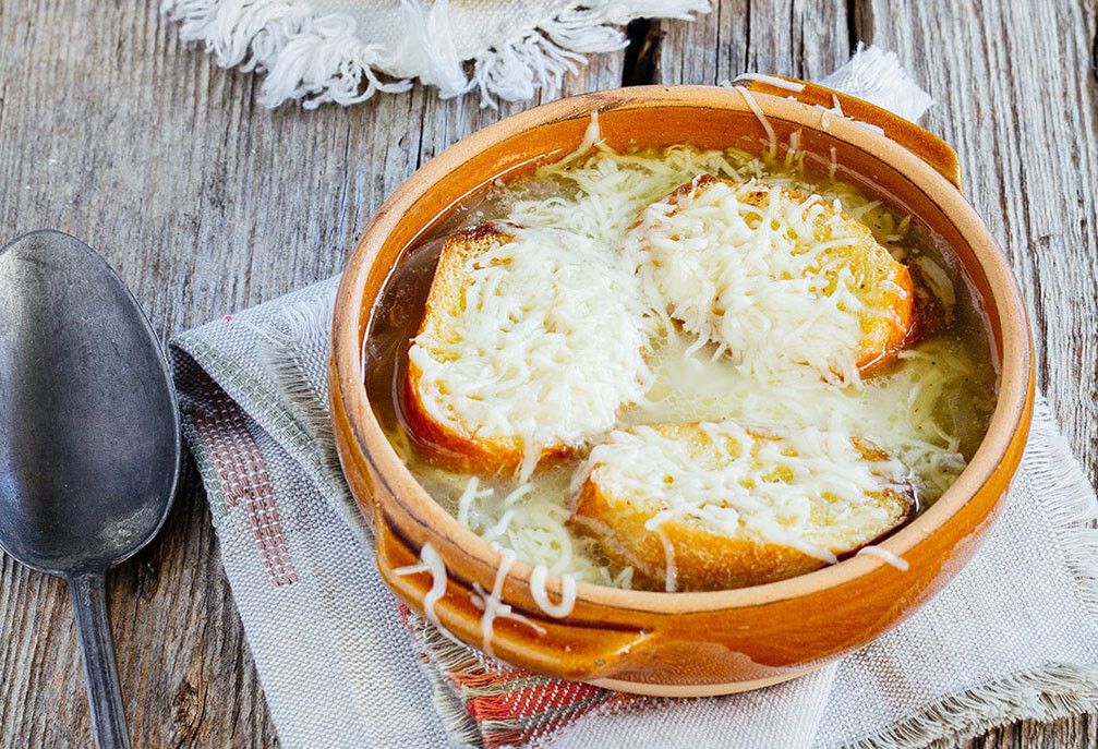 Sopa de cebolla
Ingredientes. 4 cebollas blancas grandes en juliana, 250 ml de vino blanco seco, 1 l de agua, 50 g de mantequilla, una cucharada de aceite, una cucharada de harina blanca, 100 g de queso rmmenthal rallado, una baguette, sal y pimienta negra molida.

Elaboración. Calentamos una olla con el aceite y derretimos la mantequilla. Agregamos las cebollas y salpimentamos. Cocemos a fuego lento unos 20 minutos. Agregamos la harina y removemos. Dejamos un par de minutos más antes de añadir el vino blanco y el agua sin dejar de revolver. Ajustamos el punto de sal y pimienta. Cocemos a fuego bajo unos 30 minutos. Cortamos el pan en rodajas de unos tres o cuatro cm de ancho, untamos mantequilla en ambos lados y colocamos en el horno a 180ºC unos 10 minutos. Las volteamos y dejamos otros 10 minutos. Para servir la sopa colocamos cada porción en un cuenco para horno, acomodamos el pan y espolvoreamos el queso rallado. Ponemos en el horno caliente a 220ºC 3-5 minutos.