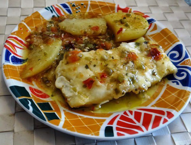 INGREDIENTES:
•	2 Lomos de Bacalao Noruego desalado no muy grueso
•	1/ Cebolla
•	½ Pimiento verde y ½ Pimiento rojo
•	2 dientes de Ajo
•	1 Chorro de Vino blanco seco
•	¼ litro caldo de Pescado o 1 Pastilla disuelta en vaso de agua
•	2 Patatas medianas cortadas planas de 1 cm de grosor


PREPARACIÓN:

1.	Hacer un sofrito con la cebolla, pimientos y ajo. Cada ingrediente debe estar bien picadito.
2.	Añadir chorrito de vino blanco seco e incorporar el caldo de pescado. 
3.	En otro recipiente, hervir en agua con sal a las patatas peladas y cortadas. Una vez listas, retiramos.
4.	A continuación ponemos el bacalao encima del sofrito, con la piel abajo pegada al sofrito, alrededor del bacalao ponemos las patatas planas y con una cuchara cogemos parte del sofrito y lo añadimos por encima de los lomos.
