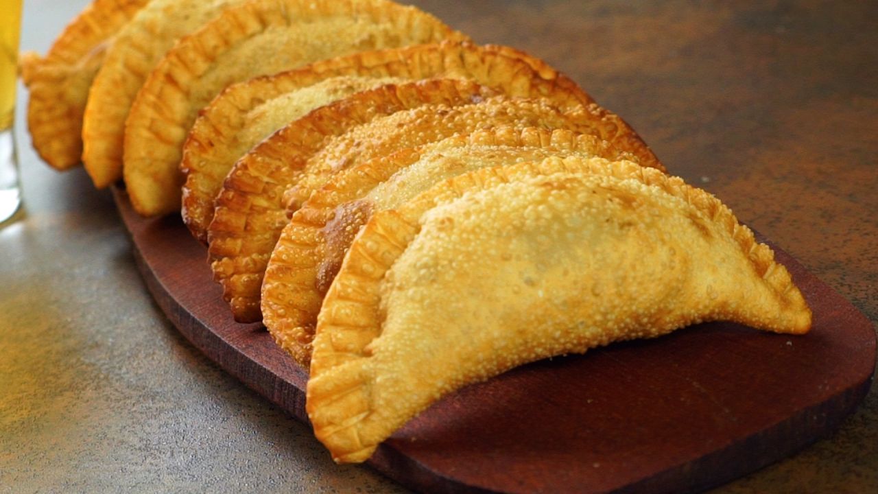 30 unds.Empanaditas.
Tiempo de preparación: 30 minutos.

Masa:
3 libras de Yuca guayada.
1 naranja agria.

Relleno:
1 libra de Pechuga de Pollo molido.
1 cebolla.
1 pimiento 
ramo de cilantro.
1 aji cubanela.
10 aceitunas rellenas.
1 taza de pasas.
Aceite para Freír.

Preparación:
Guayar y exprimir la Yuca en un lienzo hasta extraer el almidón, pasar la masa por un caldero caliente , moviendo con una cuchara de madera , hasta que comienza a cocer, agregar sal y las gotas de naranja agria, amasar con las manos o con la ayuda de una batidora.
Con un rodillo aplanar y dar forma con cortador o tenedor, rellenar con carne, queso o vegetales.
Para el relleno, cortar los vegetales, sofreír, y agregar la carne y aceitunas, dejar sofreír por 10 minutos mas.
Dejar refrescar y rellenar las catibias. Freír en abundante aceite.

Receta de la Chef Ana Mejia