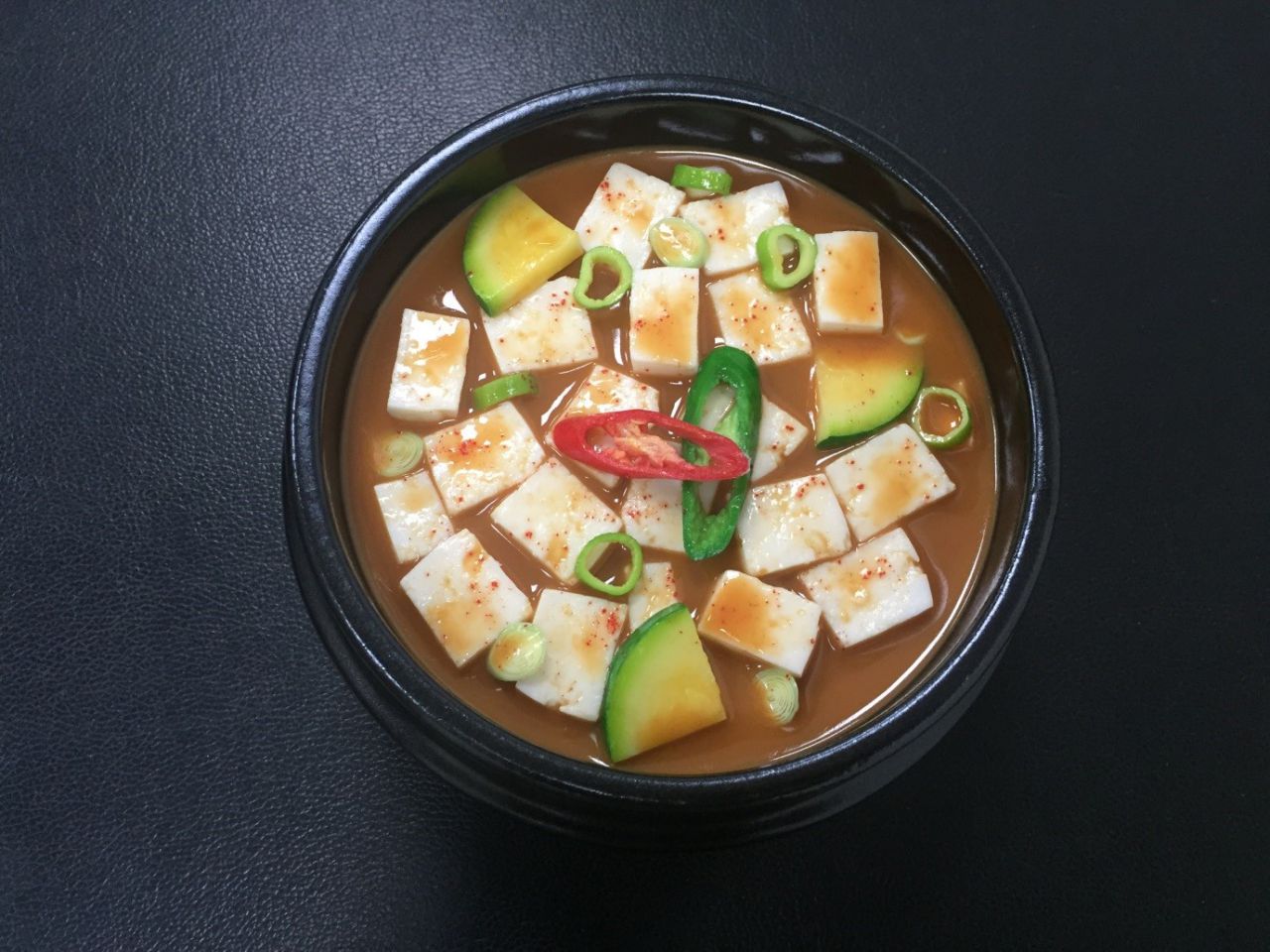 Sopa con tofu y vegetales

- Tiempo de preparación: 1 h

- Ingredientes (para 4 personas): 700g de agua, 5 cucharadas de pasta de soya, 250g de tofu, 1/2 de zucchini, 1 ají rojo, 1 ají verde, 20g de puerro, 1 cucharada de polvo de ají 

- Receta 
1) Empezamos a cortar el tofu en cubos y los ajís en rodajas. 

2) En una olla ponemos 700g de agua y 5 cucharadas de pasta de soya y la calentamos.

3) Cuando la sopa empieza a hervir, reducimos el fuego y seguimos cocinando 10 minutos más. 

4) A continuación, agregamos el tofu y el polvo de ají y lo calentamos 2 minutos más. Y ponemos los ajís y lo calentamos 1 minuto más. 







