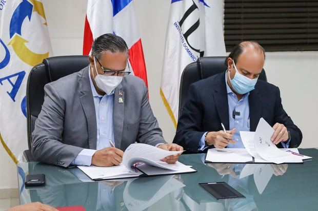 Ángel David Taveras Difo, director ejecutivo de la ODAC y Román E. Caamaño, director general del IDAC, durante la firma del acuerdo interinstitucional.