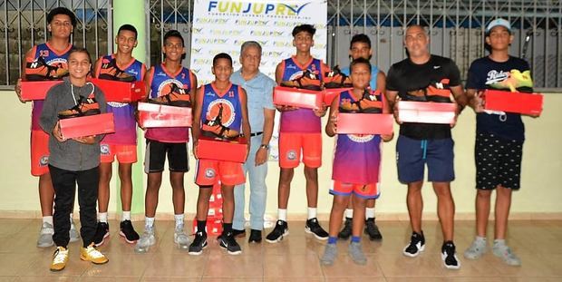 En el centro, el señor Tony Peña R, mientras entrega los tenis a los jugadores infantiles de baloncesto del CLUDEN, le acompañan, además, entrenadores y ejecutivos de esa entidad.