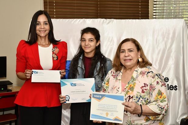 Lisbeth Grullón Fondeur recibe sus premios de manos de Claudine Nova y Mirna Pimentel.