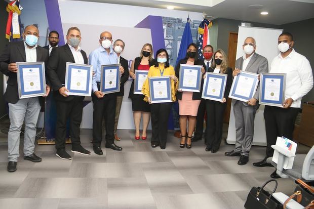 Representantes de las empresas certificadas junto a Eric B. Wolff, oficial comercial para la región del Caribe del departamento de comercio de los Estados Unidos de América; William Malamud, vicepresidente ejecutivo de la Cámara Americana de Comercio y Omar Castellanos, director ejecutivo de BASC Dominicana.
