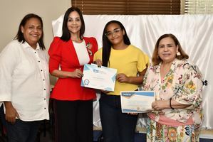 Sarah Rosario Matos recibe su certificado de manos de Siddy Roque, Claudine Nova y Mirna Pimentel.