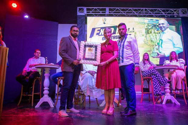 Abraham Abreu recibe el reconocimiento de manos de Aneury Pilar y la senadora Ginette Bournigal.