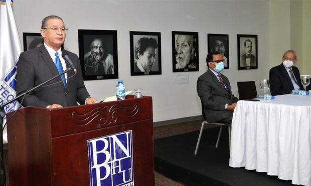 El ex-director nacional de Registro de Títulos, Wilson Gómez Ramírez, se dirige a los presentes. Se observan, en la mesa de honor, Rafael Peral Romero, director de la Biblioteca Nacional Pedro Henríquez Ureña y Jorge A. Subero Isa, ex-presidente de la Suprema Corte de Justicia.