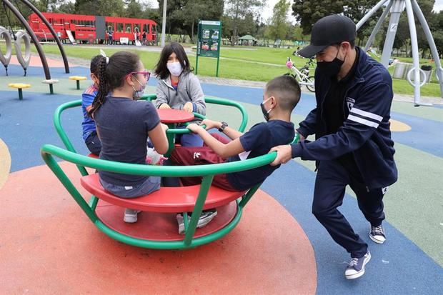 Un grupo de niños, protegidos por mascarillas, juega en el Parque Simón Bolívar de Bogotá, Colombia.