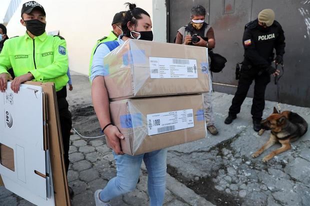 Un funcionario del Consejo Nacional Electoral ecuatoriano ingresa hoy a un centro penitenciario con las papeletas electorales para la primera jornada de votación adelantada de las elecciones generales de 2021, en Quito, Ecuador.