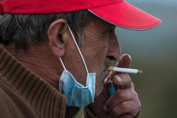 Un hombre fuma un cigarro con la mascarilla bajada, en una imagen de archivo.