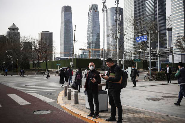 La gente permanece en la calle en medio de la pandemia de coronavirus en Pekín, China.