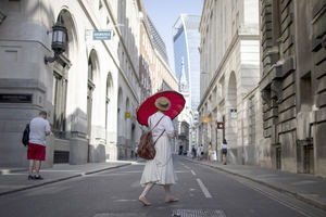 Una mujer usa un paraguas para protegerse del sol en el distrito financiero de la ciudad de Londres, Reino Unido, el pasado mes de julio, en una fotografía de archivo.