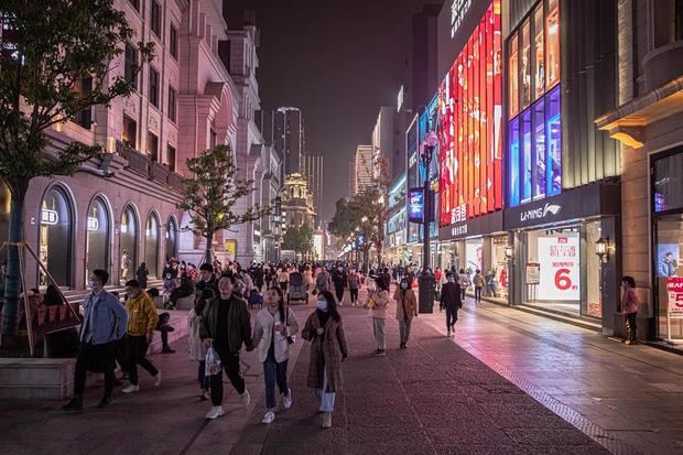 La gente camina por una calle comercial en Wuhan, China.