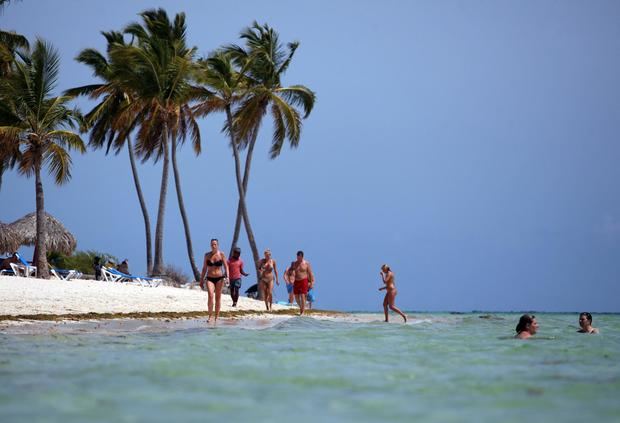 Fotografía de archivo en la que se registrá a turistas al caminar por una playa de Punta Cana (República Dominicana).