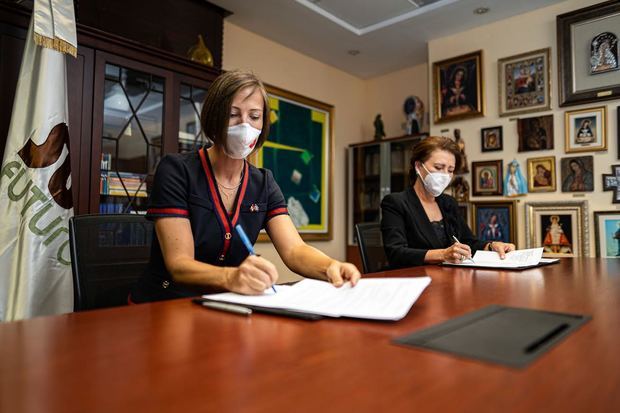 Shauna Heminguay y Melba Segura de Grullón firmando el acuerdo.