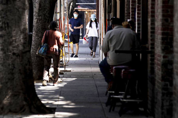 Una pareja camina con tapabocas por una calle de restaurantes en Pasadena, California (EE.UU.), el pasado 14 de julio de 2020.