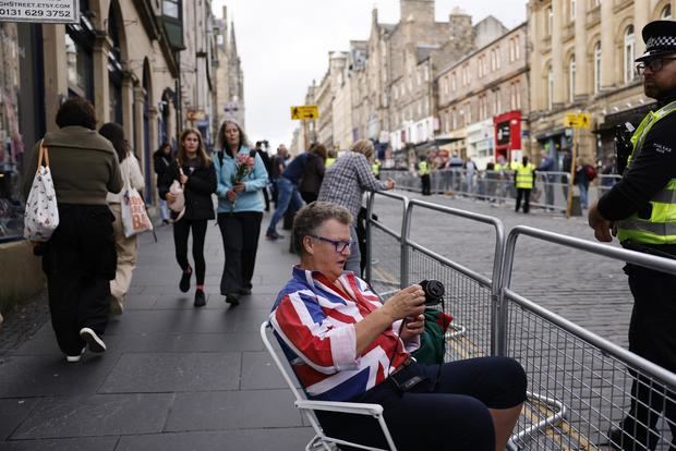 ersonas aguardan al paso de la procesión del féretro de la reina Isabel II, acompañado de miembros de la familia real, en Edimburgo, Escocia, este lunes.