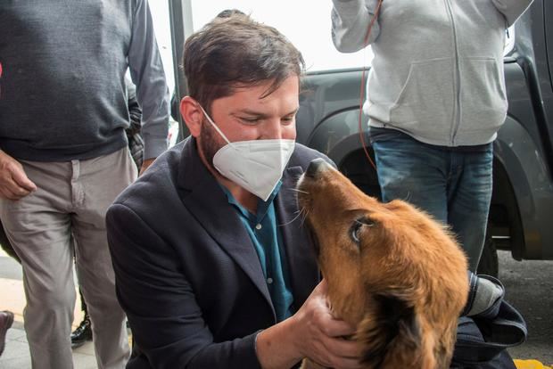 Fotografía cedida por el equipo de Prensa del presidente electo de Chile, Gabriel Boric, que lo muestra mientras abraza a su perro 'Brownie' al llegar a su ciudad natal, Punta Arenas (Chile), este 30 de diciembre de 2021.