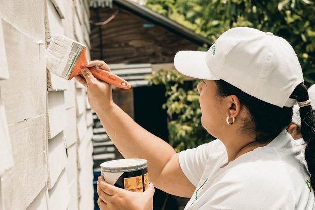 Una voluntaria del Banco Caribe pinta una de las casas en San Luis.
