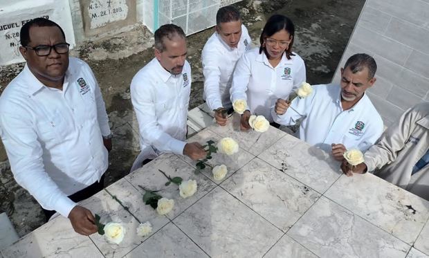 Juan Pablo Uribe y sus colaboradores, depositan una rosa blanca en la tumba de Rufino de la Cruz.