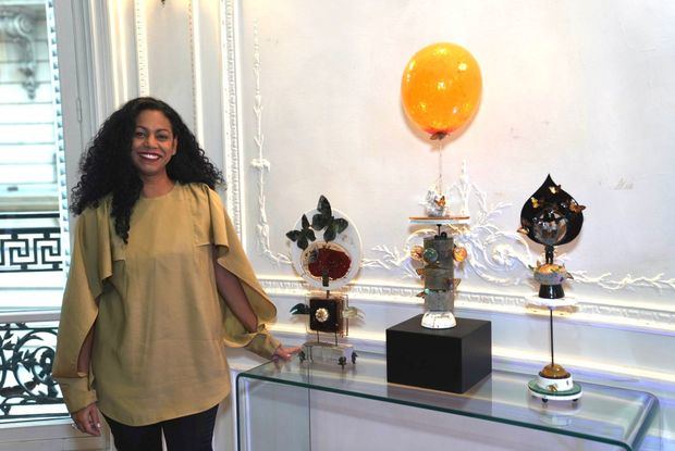 Artista Melissa Roedán junto a algunas de sus obras en las oficinas de la Embajada Dominicana en París.