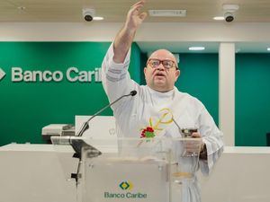 El diácono Pedro Mateo bendice la sucursal de Banco Caribe en la plaza comercial Ágora Mall.
