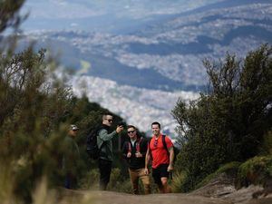 Un grupo de turistas fue registrado este sábado al tomarse una foto, con la ciudad de Quito al fondo y al visitar el teleférico, en la capital ecuatoriana.