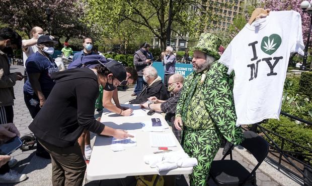 El voluntario Todd Hinden (R) entrega cigarrilos de marihuana a vacunados para la COVID-19 en un evento en Nueva York, en una fotografía de archivo. 