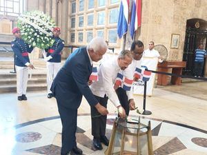 Roque Zabala, Juan Pablo Uribe y Juan Alberto Michel, depositan una ofrenda floral en la llama votiva.