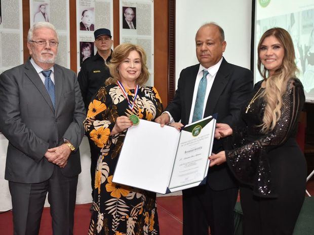 Amarilis Durán recibe el reconocimiento en nombre de Referencia Laboratorio Clínico, de manos de Sergio Solís Taveras, presidente de la premiación y otros colaboradores.