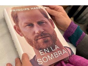 Una mujer sostiene un ejemplar de 'En La Sombra', la traducción al español de las memorias del Príncipe Harry 'Spare'.