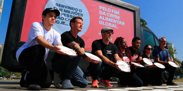 Fotografía de archivo de activistas sostienendo platos vacíos con la frase “Fin de la crisis alimentaria mundial ya! #platosvaciosno” durante un acto de campaña contra el hambre, en Río de Janeiro (Brasil).