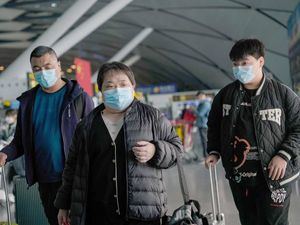 Pasajeros con mascarillas caminan con su equipaje en el Aeropuerto Internacional de Nanning Wuxu en Nanning, China, el pasado 18 de enero. 