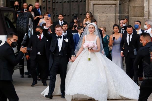 Campeón mundial de peso supermedio de la Asociación Mundial de Boxeo (AMB) y del Consejo Mundial de Boxeo (CMB) Saul 'Canelo' Álvarez y su esposa Fernanda Gómez, saludan hoy, al salir de su boda en la catedral de Guadalajara, estado de Jalisco, México.