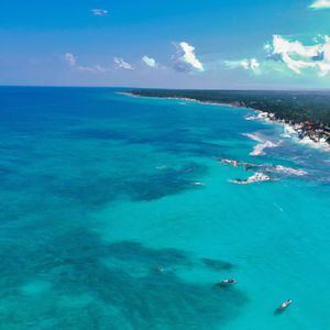 El texto describe una playa paradisíaca con aguas cristalinas y arena blanca. Se enfatiza la importancia de cuidar este ecosistema marino, evitando arrojar basura al mar y protegiendo los arrecifes de coral. También se menciona la necesidad de regular el turismo para evitar la sobreexplotación de los recursos naturales. Se invita a disfrutar de esta belleza natural con responsabilidad y respeto hacia el medio ambiente.