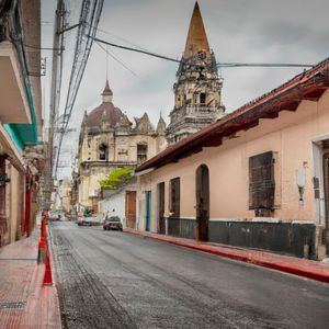 El texto describe una ciudad bulliciosa y llena de vida, con calles estrechas y coloridas fachadas. Se mencionan los vendedores ambulantes ofreciendo una amplia variedad de productos, desde frutas frescas hasta artesanías locales. También se destaca la arquitectura colonial de los edificios históricos y la presencia de monumentos emblemáticos. Se invita a los lectores a sumergirse en el vibrante ambiente urbano y descubrir la riqueza cultural de la ciudad.