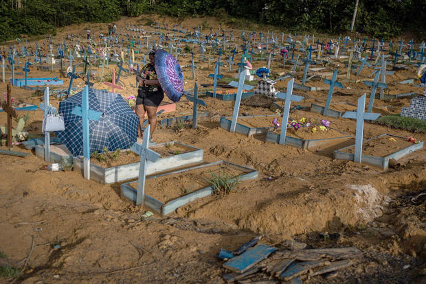 Personas se protegen del sol mientras visitan las tumbas de familiares en el área destinada a las víctimas del Covid-19 en el cementerio Nossa Senhora Aparecida, en Manaos, en una fotografía de archivo.