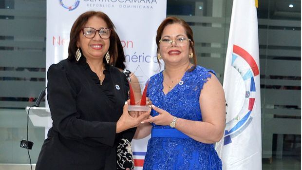 Kathy Grullon entrega un reconocimiento a Luisa Abinader.