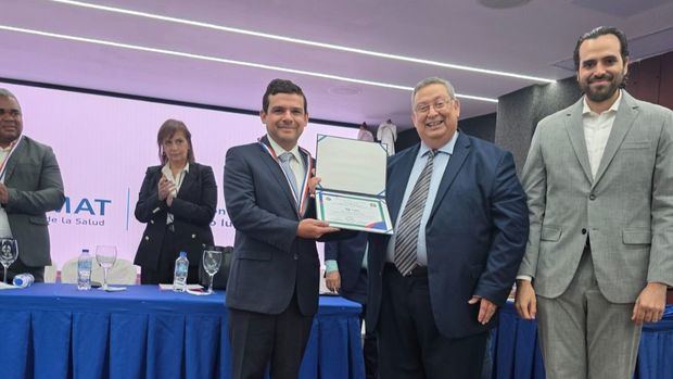 Representante de CEDIMAT recibiendo el reconocimiento.
