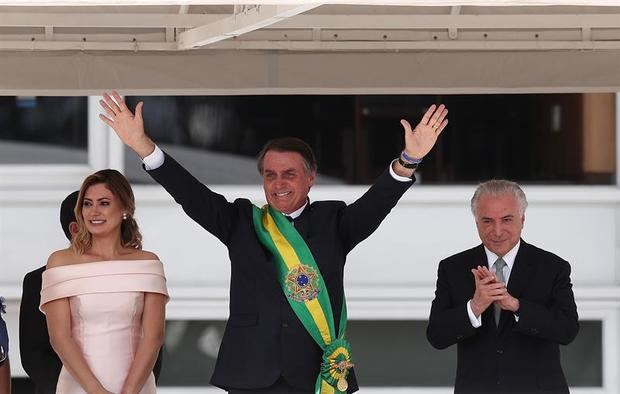  El nuevo presidente de Brasil, Jair Bolsonaro, su esposa Michele, y el expresidente Michel Temer durante una ceremonia celebrada hoy en el Palacio de Planalto, Brasilia (Brasil), en la que Bolsonaro recibió la banda presidencial de parte de su predecesor. 