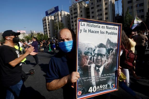 Un hombre sostiene un afiche del expresidente Salvador Allende durante una concentración en la Plaza Dignidad, antigua Plaza Italia, tras conocerse la muerte de Lucía Hiriart, esposa del dictador Augusto Pinochet, que falleció a sus 99 años, hoy en Santiago, Chile.
