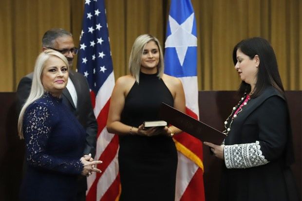 La secretaria de Justicia de Puerto Rico, Wanda Vázquez (i) sonríe este miércoles junto a su esposo, el juez José Díaz Reveron (2-i) y su hija, Beatriz Díaz (c), durante la juramentación como nueva gobernadora de Puerto Rico, ante la jueza presidenta del Tribunal, Maite Oronoz (d), encargada de tomar la juramentación, en San Juan (Puerto Rico). 