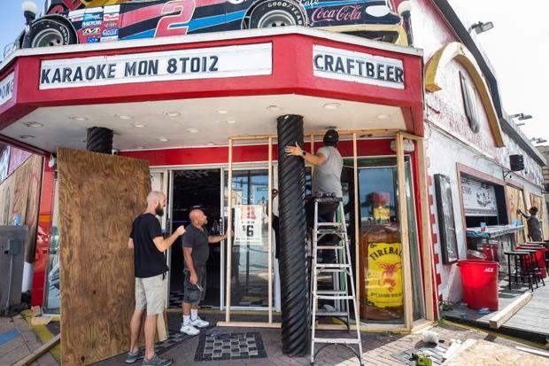 Trabajadores instalan madera frente a puertas de vidrio este domingo dentro de los preparativos para el impacto del huracán Dorian en Daytona Beach, Florida (Estados Unidos). 