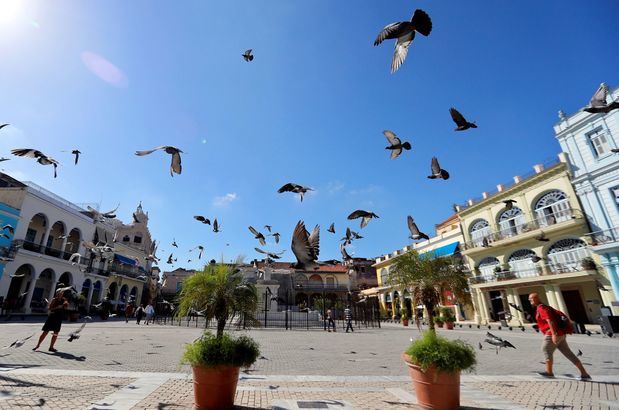 Turistas caminan entre las palomas en una plaza este viernes en La Habana (Cuba). Las autoridades cubanas se suman este viernes a la celebración del Día Mundial del Turismo con estrategias enfocadas a la diversificación de las propuestas de la industria de los viajes y el cuidado del medio ambiente. La isla cuenta con más de 70 mil habitaciones hoteleras en unos 300 establecimientos distribuidos por todo el país. 