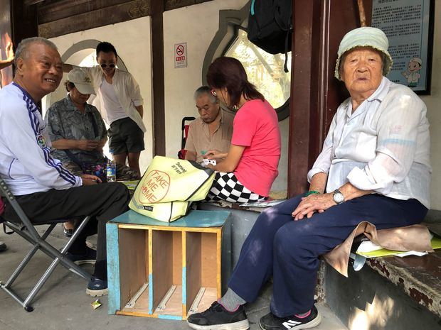 La señora Gao (d) juega a las cartas con un grupo de amigos en el parque de Tuanjiehu, en Pekín, China. A sus 101 años, es historia viva del país, de una China que tiene 31 menos que ella, ya que el 1 de octubre se celebrará el septuagésimo aniversario desde que Mao Zedong declarara la fundación de la República Popular desde la Puerta de Tiananmen.