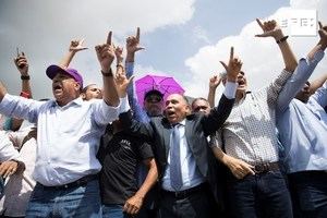 El dirigente Radhamés Jiménez (c) habla ante cientos de seguidores de Leonel Fernández, expresidente de la República y precandidato presidencial del oficialista Partido de la Liberación Dominicana (PLD), que se manifiestan este martes frente a la sede de la Junta Central Electoral para reclamar contra los resultados de las primarias del pasado domingo, en Santo Domingo (República Dominicana).