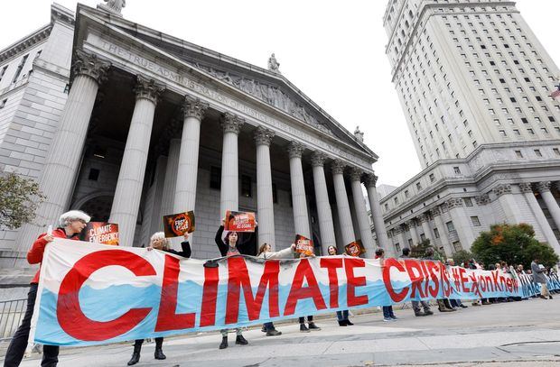 Un grupo de manifestantes se reúne fuera de un juzgado de la ciudad de Nueva York para un mitin que coincide con el inicio de un caso legal contra Exxon Mobile en Nueva York, Nueva York, EE. UU.